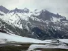 ラウターレ峠 - メイヘ山地（雪に覆われた山）の景色を望むLautaret峠（道）の下り坂。エクラン国立公園内