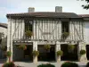 富尔塞 - 半木结构的房子，装饰着天竺葵（鲜花），住在Fourcès市政厅