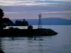 日内瓦湖 - 湖，浮桥，有信号量的码头和小山在日落的背景中