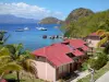 桑特人 - Terre-de-Haut岛的房子，可以看到加勒比海和漂浮在水面上的帆船