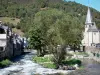 阿雷劳 - Chapel Saint-Exupère教堂和河边村庄的房屋，树木在水边;在Bigorre