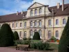 Abbaye de Cluny - Abbaye bénédictine : bâtiment conventuel et jardin (banc, arbustes taillés, rosiers, fleurs)