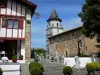 Ainhoa - Église Notre-Dame de l'Assomption avec son clocher carré à quatre étages, cimetière et maison à colombages rouges du village basque