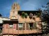 Albi - Stenen huis met houten zijkanten met bloemen en de klokkentoren van de kathedraal van St. Cecilia