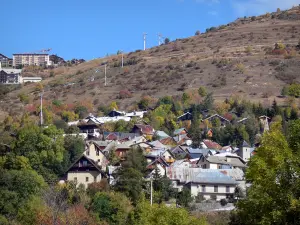 Alpe d'Huez - Casas, chalés e edifícios do inverno e verão esportes resort (estação de esqui), árvores nas cores do outono