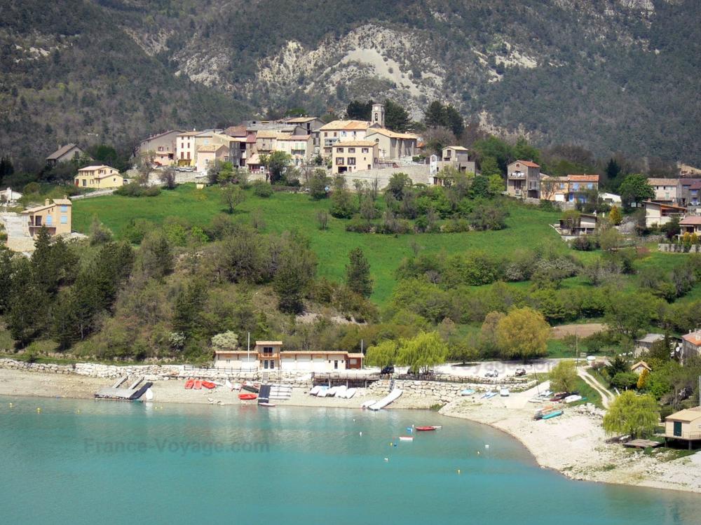Guide des Alpes-de-Haute-Provence - Saint-Julien-du-Verdon - Église et maisons du village surplombant le lac de Castillon aux eaux couleur émeraude, base nautique ; dans le Parc Naturel Régional du Verdon