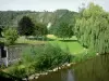Alpes Mancelles - Rio Sarthe, banco plantado com árvores e colina verde; em Saint-Léonard-des-Bois, no Parque Natural Regional da Normandia-Maine
