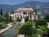 Guide des Alpes-Maritimes - Villa Ephrussi de Rothschild - Palais à l'italienne et grand bassin du jardin à la française, collines en arrière-plan ; à Saint-Jean-Cap-Ferrat