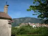Alta Rocca - Pequeña iglesia, los árboles, pueblo de Sainte-Lucie-de-Tallano y montañas en el fondo