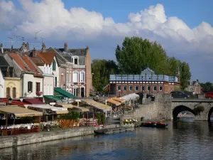 Amiens - Saint-Leu wijk: huizen, outdoor restaurants en cafes langs het water, brug over het kanaal, wolken in de lucht