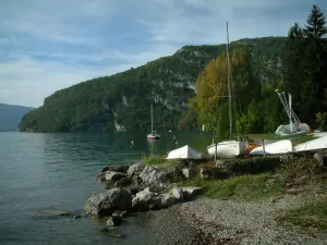 Meer van Annecy - Op Talloires strand, rotsen, meer, zeilen, heuvel en bomen in de herfst