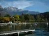 Annecy lake - Wooden pontoon, lake, boats, trees with autumn colours and mountains