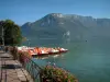 Annecy lake - In Annecy: flower-bedecked shore, moored pedal boats, lake and mount Veyrier