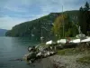 Annecy lake - In Talloires: beach, cliffs, lake, sailboats, trees in autumn and hill