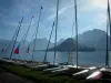 Annecy lake - In Talloires: catamarans lined up on the shore with view of the lake and mountains