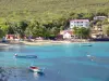 Anse Dufour - Praia de Dufour Cove, fachadas de casas e barcos flutuando nas águas azul-turquesa do Mar do Caribe; na comuna de Anses-d'Arlet