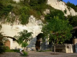 Aubeterre-sur-Dronne - Exterior da igreja monolítica de São João (igreja subterrânea) e praça decorada com árvores