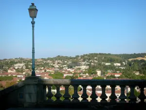 Auch - Lamppost and railing of the monumental staircase in the foreground, view of the Gers valley and the rooftops of the lower town