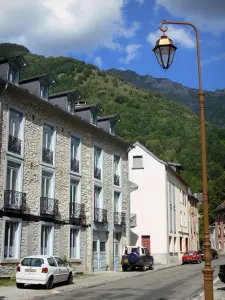 Aulus-les-Bains - Lampione, strade e facciate di case nel villaggio (spa), foreste e montagne dello sfondo Alto Couserans