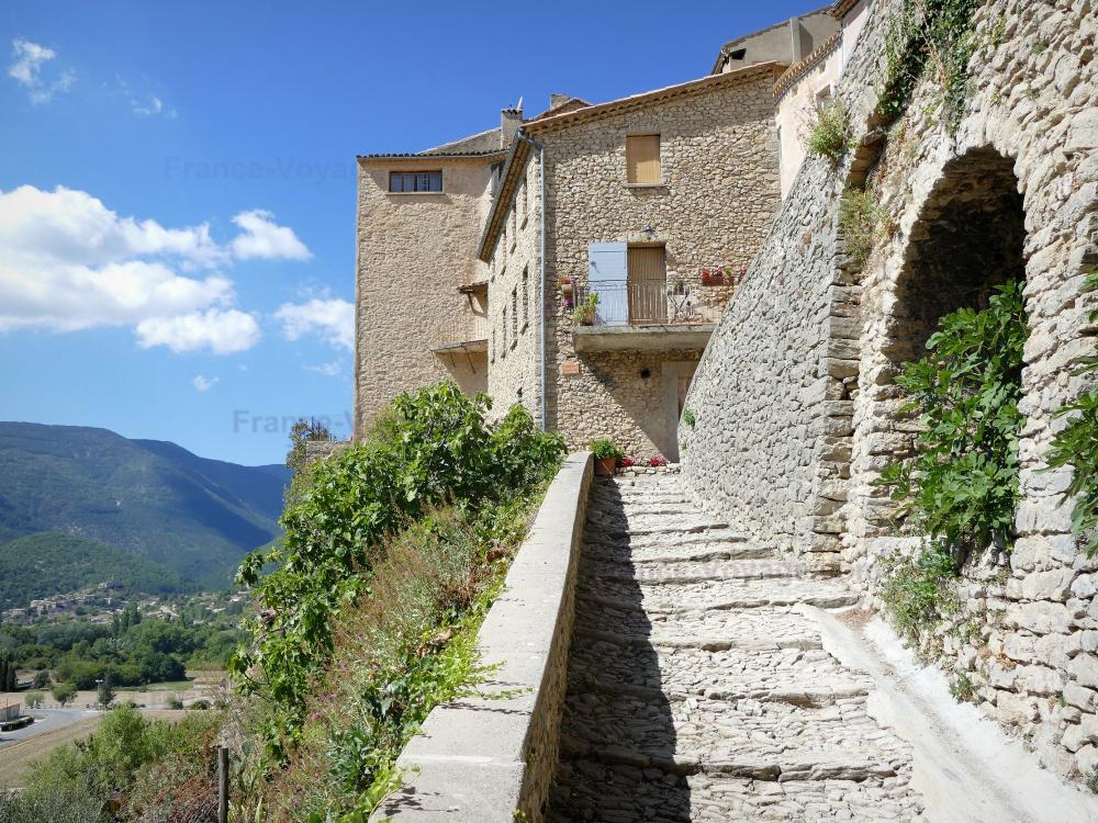 Guide d'Auvergne-Rhône-Alpes - Montbrun-les-Bains - Escalier pavé de galets et maisons en pierre du village médiéval