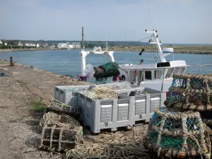 Barneville-Carteret - Quay of the port with fishing drawers and ropes, moored fisherman boat, the Channel (sea) and houses of the seaside resort