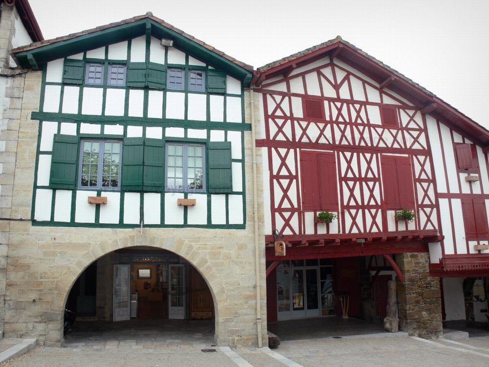 La Bastide-Clairence - Facades of houses with red and green timbered on the Place des Arceaux square