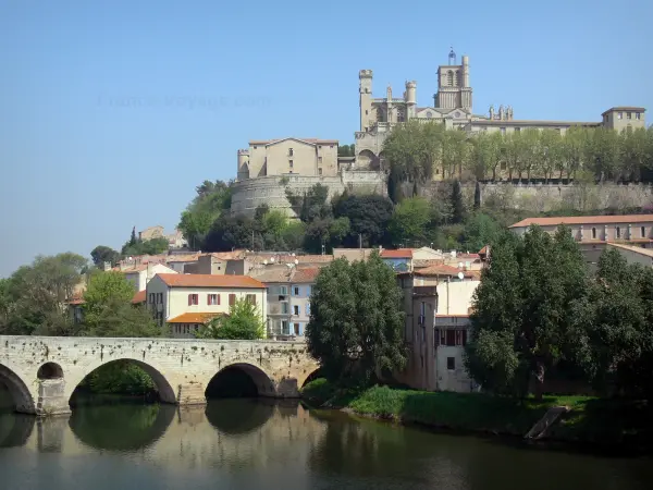 Béziers - Saint-Nazaire cathedral of Gothic style dominating the houses of the city, the Vieux bridge and the Orb river, trees along the water