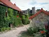 Brancion - Ruelle du village bordée de maisons et château féodal en arrière-plan