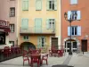 Briançon - Alta ciudad (ciudadela Vauban Vauban ciudad): Place d'Armes con una cafetería y un poste de luz y coloridas fachadas del casco antiguo