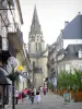 Brive-la-Gaillarde - Palmen en winkels van de straat Toulzac met uitzicht op de klokkentoren van de Saint-Martin collegiale