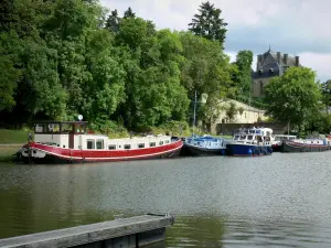 Canal du Nivernais - Port de Châtillon-en-Bazois avec ses péniches amarrées, verdure, et partie du château de Châtillon-en-Bazois en arrière-plan