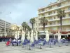 Canet-en-Roussillon - Terrasse de café, palmiers et façades d'immeubles de la station balnéaire