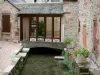 La Canourgue - Canal de l'Urugne, pots de fleurs, et façades de maisons du village