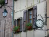 O Canourgue - Fachada do relógio e da casa com janelas embelezadas com flores