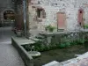 O Canourgue - Canal de Urugne e fachadas de casas na aldeia