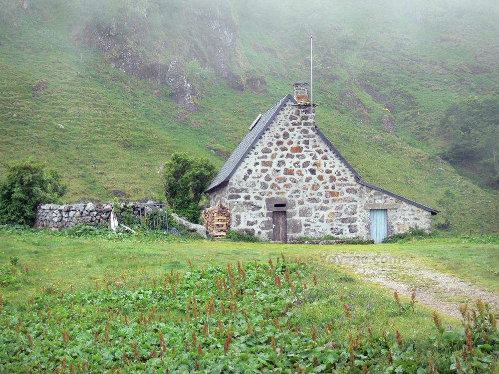 Guide du Cantal - Monts du Cantal - Parc Naturel Régional des Volcans d'Auvergne : grange en pierre dans une nature verdoyante