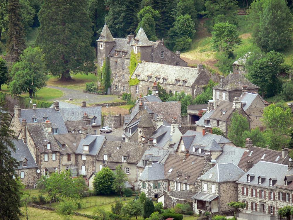 Guide du Cantal - Paysages du Cantal - Parc Naturel Régional des Volcans d'Auvergne : vue sur le château de Lamargé et les maisons du village de Fontanges