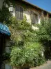 Castellet - Arbustos em flor, trepadeiras, poste de luz e casa da vila medieval
