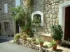 Castellet - Casa de pedra na vila medieval com vasos de plantas e arbustos