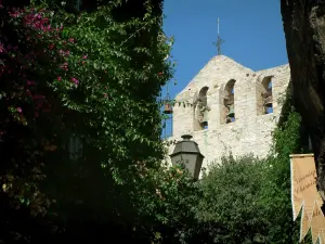 Le Castellet - Bougainvillea flowers, lamppost, pennants, creepers, tree and church of the medieval village