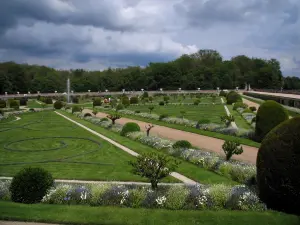 Castelo de Chenonceau - Jardim de Diane de Poitiers com seu jato de água, seus arbustos e seus parterres franceses, árvores e nuvens no céu