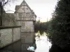 Castillo de Saint-Germain-de-Livet - La mitad de madera mansión, un foso con los cisnes y los árboles en el Pays d'Auge