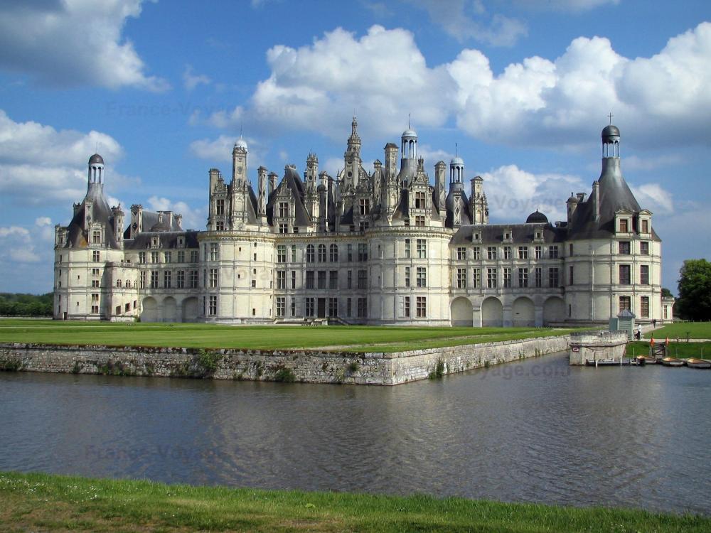 Guide du Centre-Val de Loire - Château de Chambord - Château Renaissance, pelouses, canal et nuages dans le ciel bleu