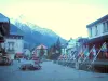 Chamonix - Зимний и летний спортивный курорт (столица альпинизма): площадь с лавками, флагами, домами и видом на массив Монблан