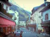 Chamonix - Зимний и летний спортивный курорт (столица альпинизма): торговая улица с домами и магазинами, на заднем плане массив Монблан