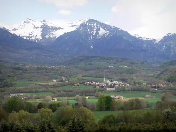 Champsaur-Tal - Kirche und Häuser des Dorfes Saint-Julien-en-Champsaur, Wiesen, Bäume und Berge mit schneebedeckten Gipfeln