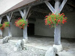 Charroux - Hall houten pilaren versierd met geraniums (bloemen)