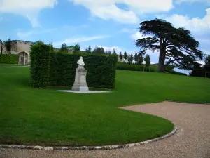 Château d'Amboise - Bust of Leonardo da Vinci, trees and lawn of the park, clouds in the blue sky