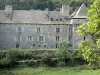 Château de la Baume - Façade du château entourée de verdure ; sur la commune de Prinsuéjols