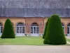 Château de Bouges - Facade of the Orangery and clipped shrubs; in the town of Bouges-le-Château